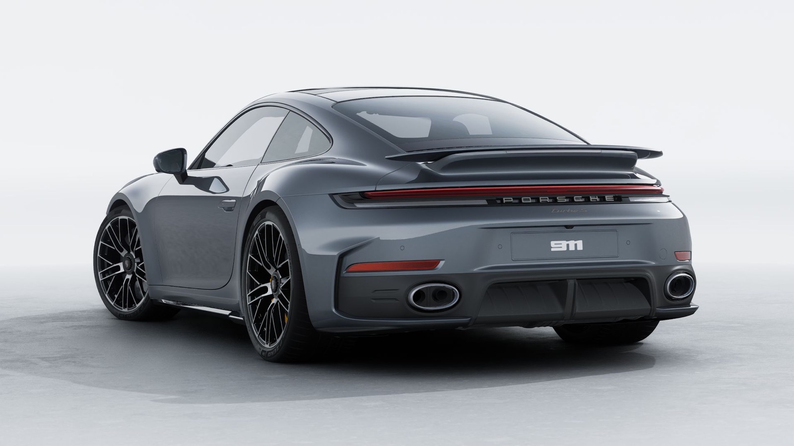 Porsche 911 Turbo S rear three-quarter view showing the wide body, light bar and titanium exhaust outlets