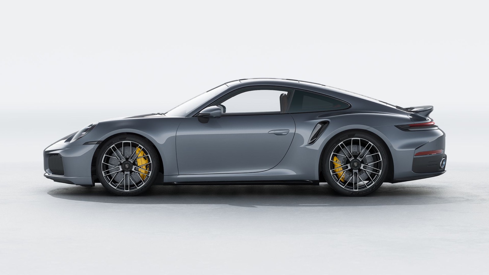 Porsche 911 Turbo S in Vanadium Grey Metallic, side profile with 20 and 21-inch black wheels